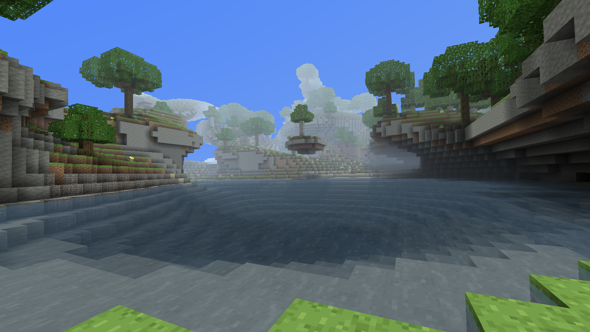 A lake below forested stone cliffs and overhangs in daylight